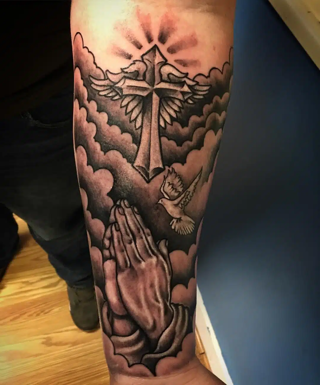 Praying hands with clouds tattoo